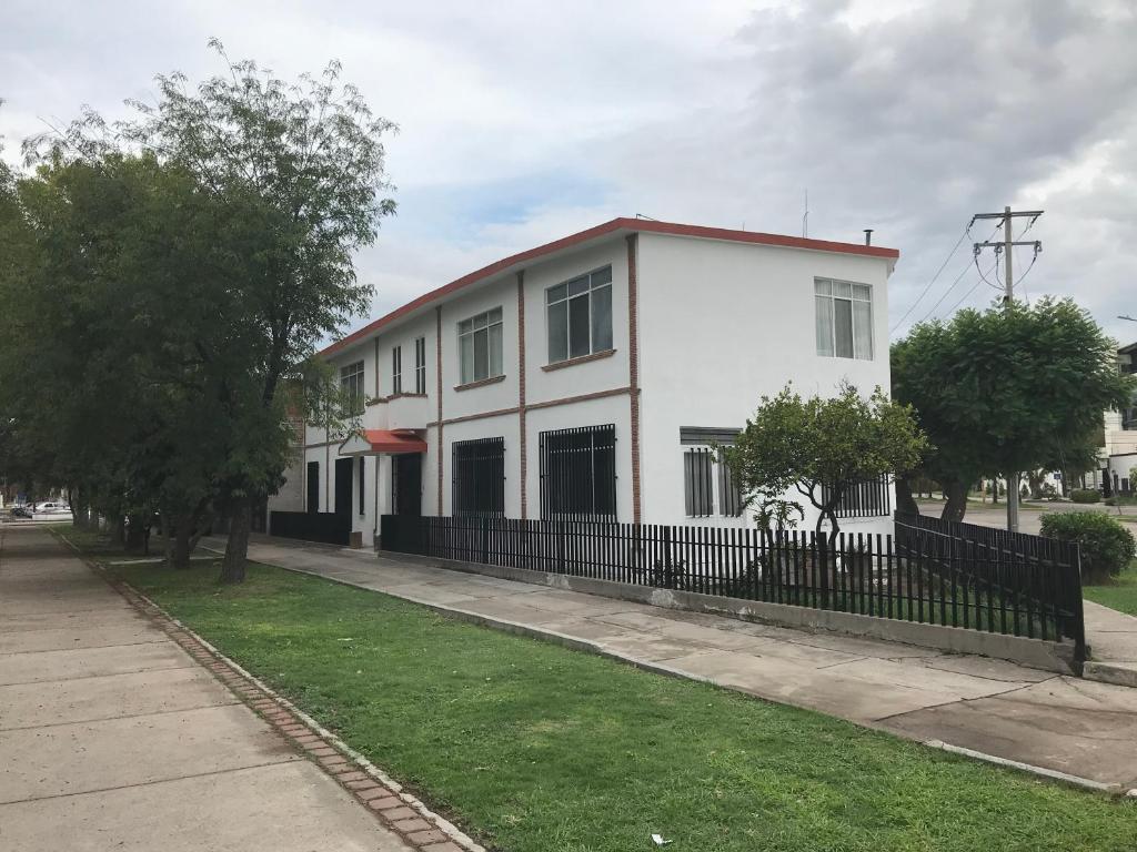 阿瓜斯卡连特斯Antigua Casa de la Alameda的前面有栅栏的白色房子