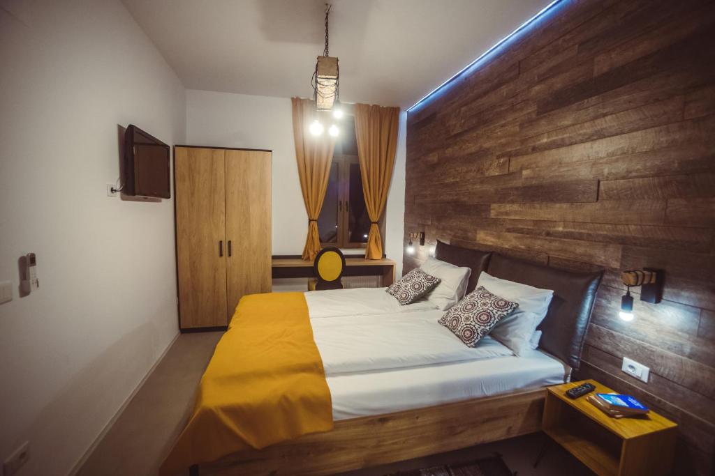 蒂米什瓦拉TimHouse的一间卧室配有一张大床和木制床头板