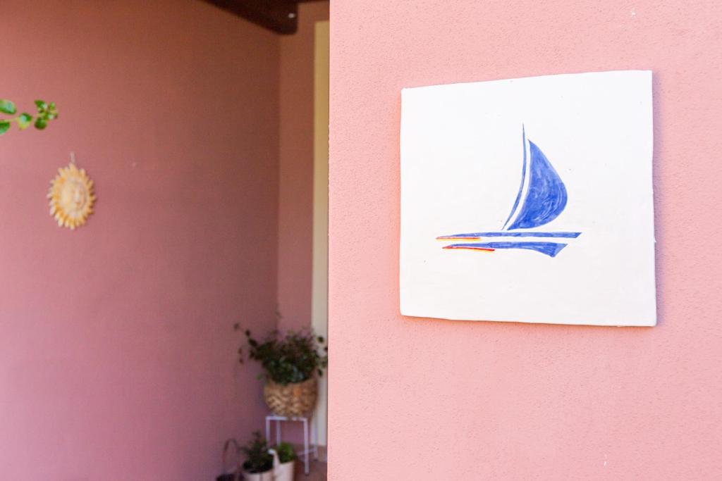 奇亚B&B La Vela Chia的粉红色墙上的帆船画