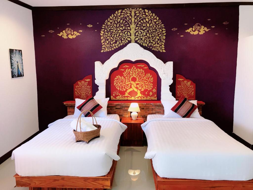 素可泰Phiphu Art and Gallery Boutique Sukhothai的紫色墙壁客房的两张床