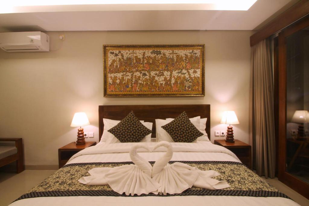 乌布The Kertha Ubud的一间卧室配有一张带两只天鹅的毛巾床