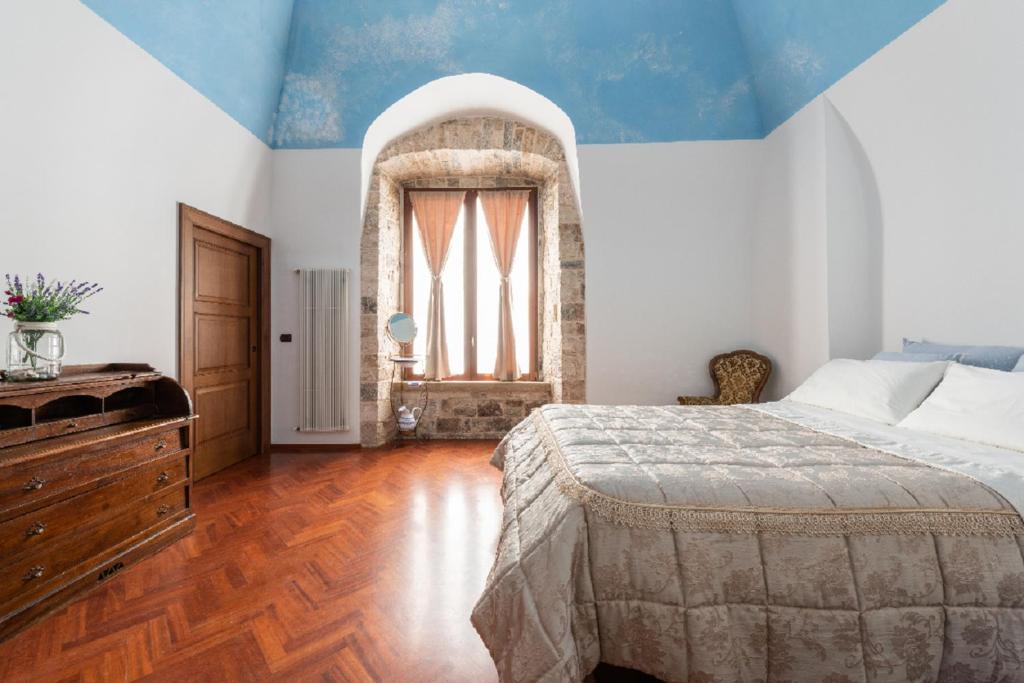 焦维纳佐Palazzo Morola XIV century的一间卧室设有一张大床和一个窗户。