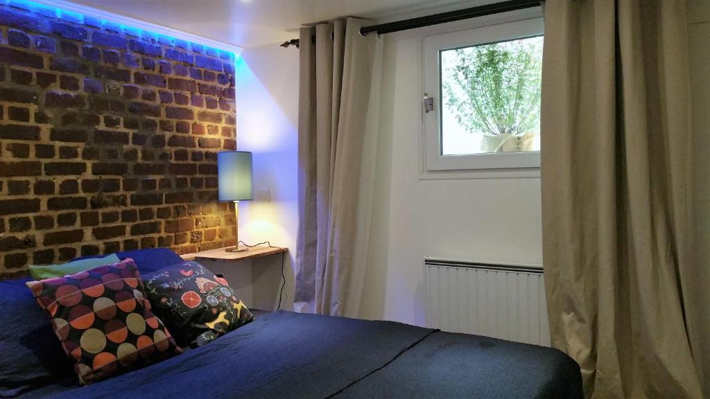 Le RaincyDOUX COCON DE 50 m2 PARIS-LE RAINCY的一间卧室设有砖墙和一张床