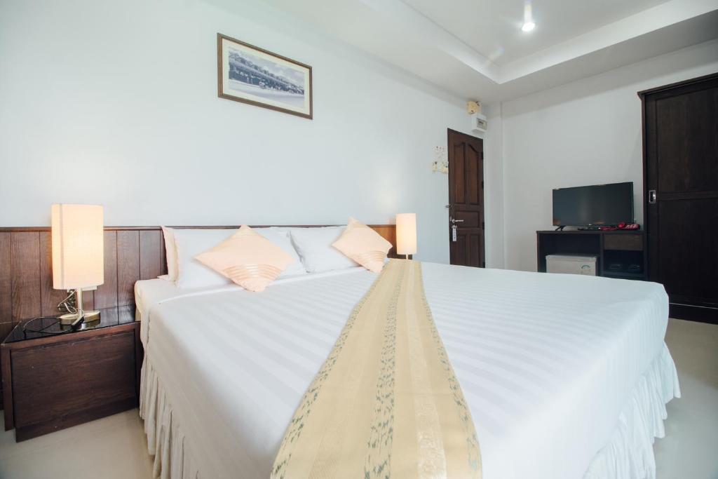 华欣Iyara Hua Hin Lodge的卧室配有一张带两个枕头的大白色床