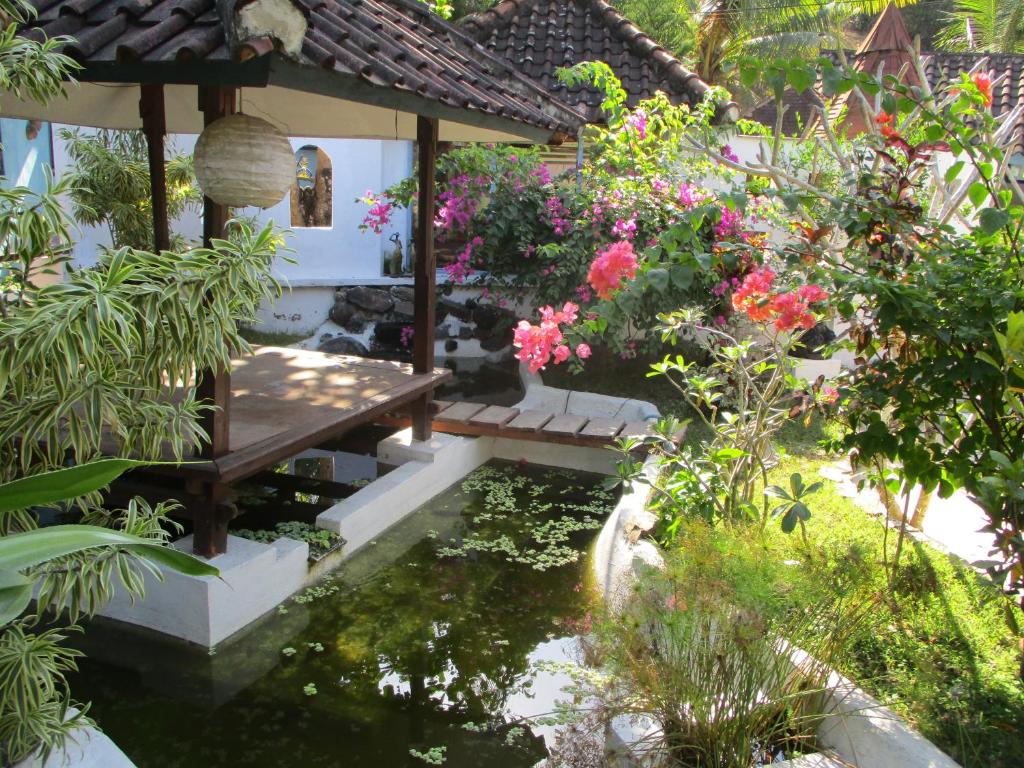 圣吉吉拉卡萨客栈的花园,花园内设有池塘、长凳和鲜花