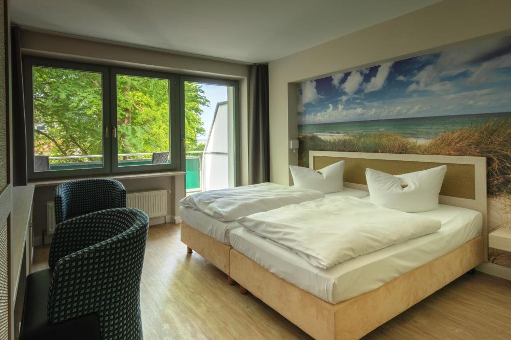 格拉尔-米里茨Hotel Haus am Meer的卧室配有一张床,墙上挂有绘画作品