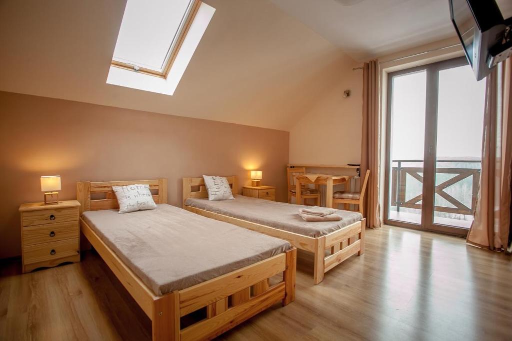 斯克拉斯卡波伦巴Pokoje Siódme Niebo的一间卧室设有两张单人床和一个天窗