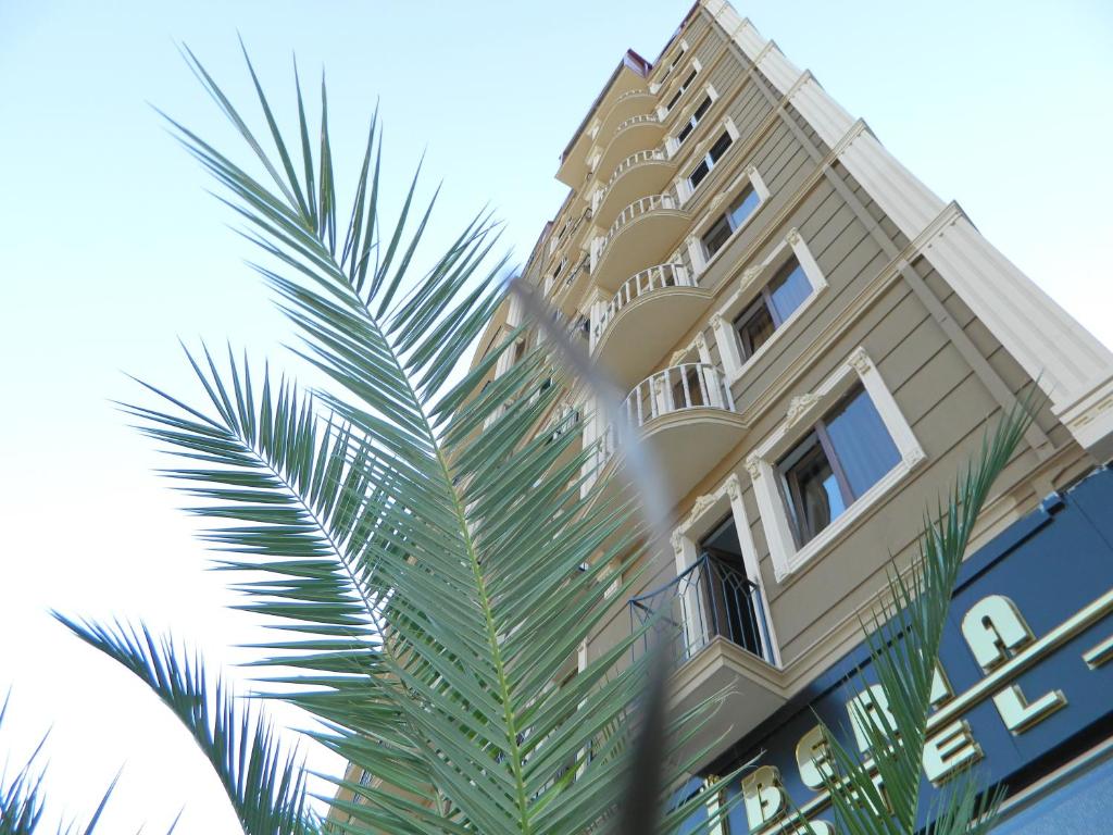 巴统伊比利亚酒店的一座高大的建筑,前面有一棵棕榈树