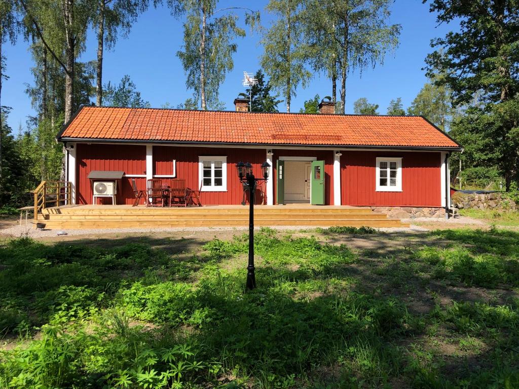 EdsbroNedanby | Cottage | Idyllic location | Porch | Grill的田间中的一个红色房子
