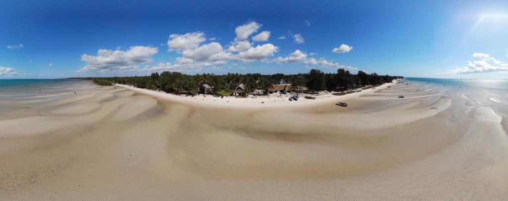 维兰库卢什Vilancool Beach Resort的享有远处树木繁茂的沙滩的景色