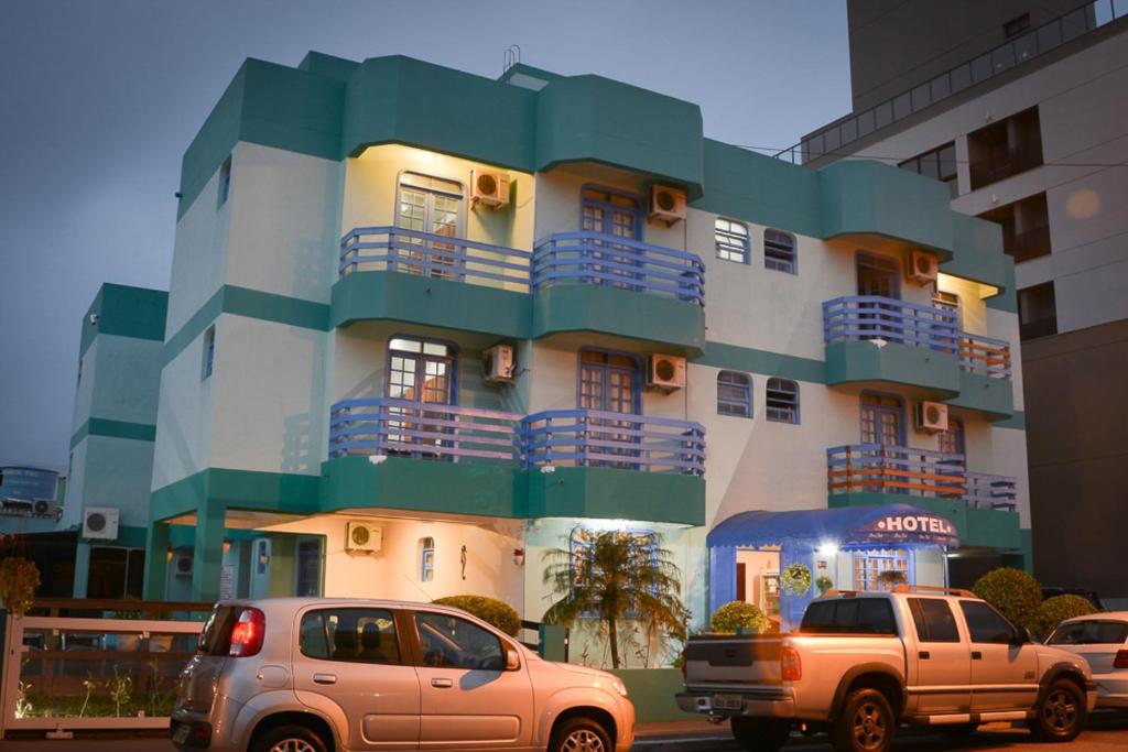 弗洛里亚诺波利斯Dom Fish Hotel & Rede Hs Hotelaria的前面有汽车停放的建筑