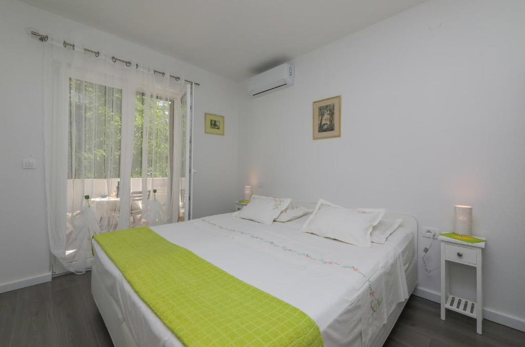苏佩塔尔Apartment M&J Supetar的白色的卧室设有一张大床和一个窗户