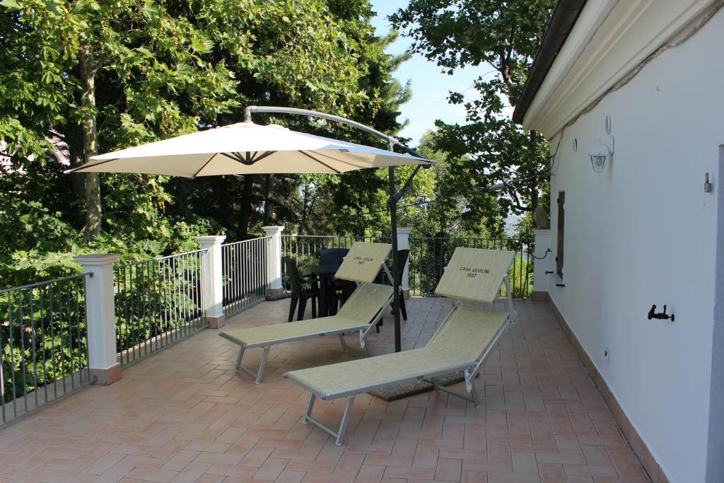 MontescudoCasa Ugolini since 1857的庭院配有桌子、遮阳伞和椅子