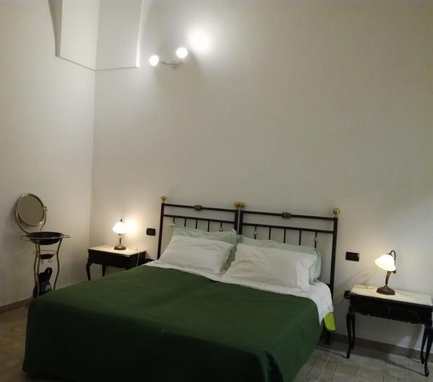 莱韦拉诺La casa di Mela的一间卧室配有一张带绿毯的床和两盏灯。