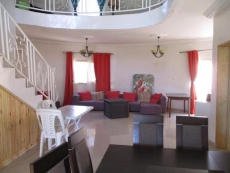 萨利波图尔Villa case authentique ,的客厅配有红色窗帘和沙发