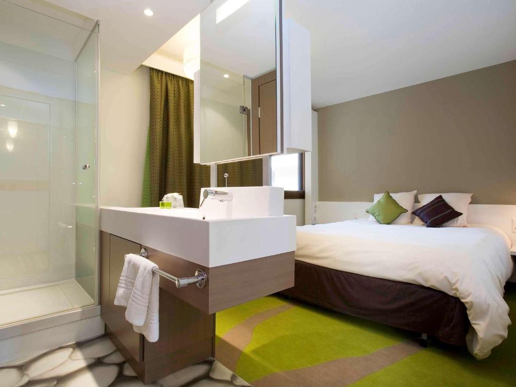 梅里尼亚克宜必思尚品波尔多机场酒店的浴室设有床、水槽和镜子