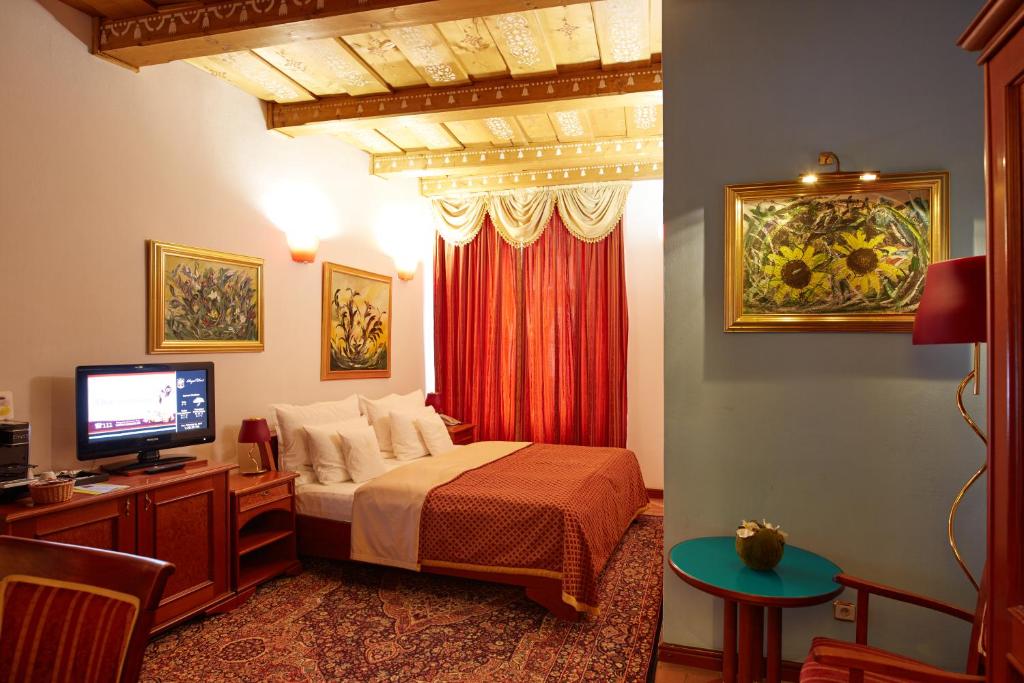 布尔诺里克皇家酒店的一间卧室配有一张床、一台电视和一张桌子