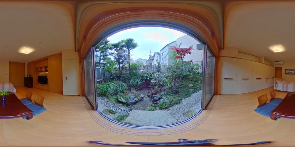 东京Shinjuku Garden House的一个带花园的房间内的一个大圆窗