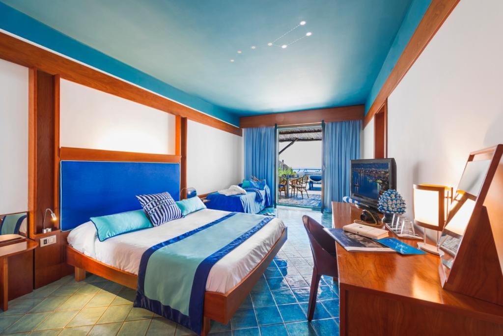 马萨鲁布朗斯罗司考格里奥酒店的一间卧室配有一张床、一张书桌和一台电视