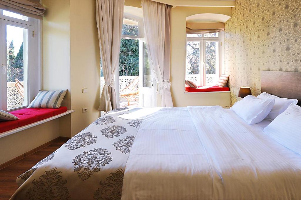 第比利斯Tekla Palace By Urban Hotels的一间卧室设有一张大床和两个窗户。