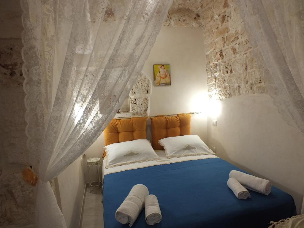 切列梅萨皮卡Casa Cuore di Pietra "STONEHEART HOME"的一间卧室配有蓝色的床和白色窗帘