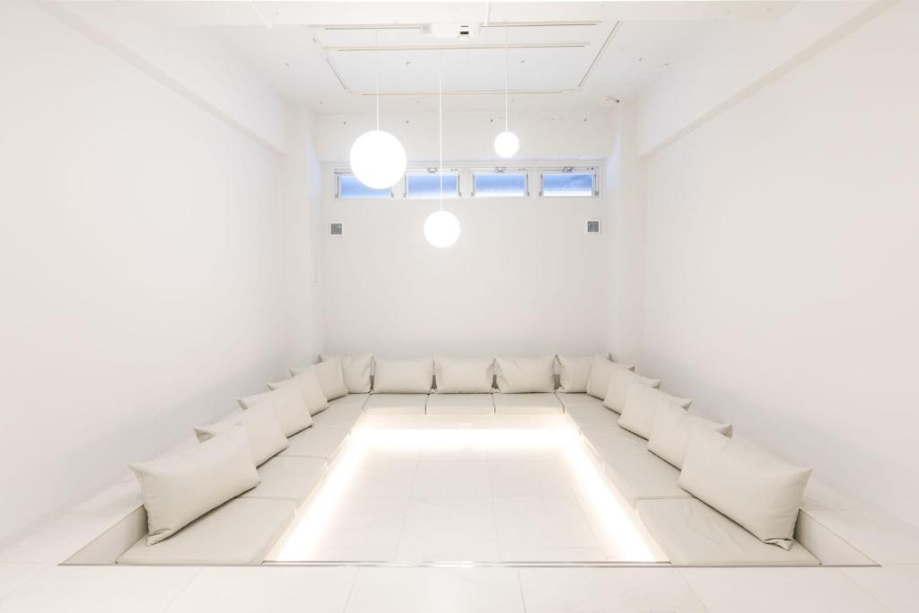 京都TSUKIMI HOTEL的白色的客房配有白色的椅子和沙发