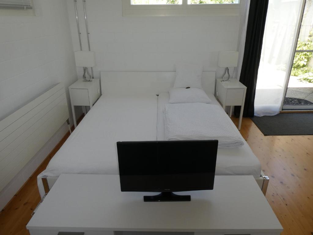 Ueberstorf优雅住宿加早餐旅馆的客房设有三张床,书桌上配有电脑