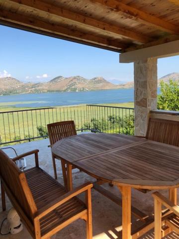 波德戈里察Skadar lake house Bobija的一张木桌和椅子,享有水景