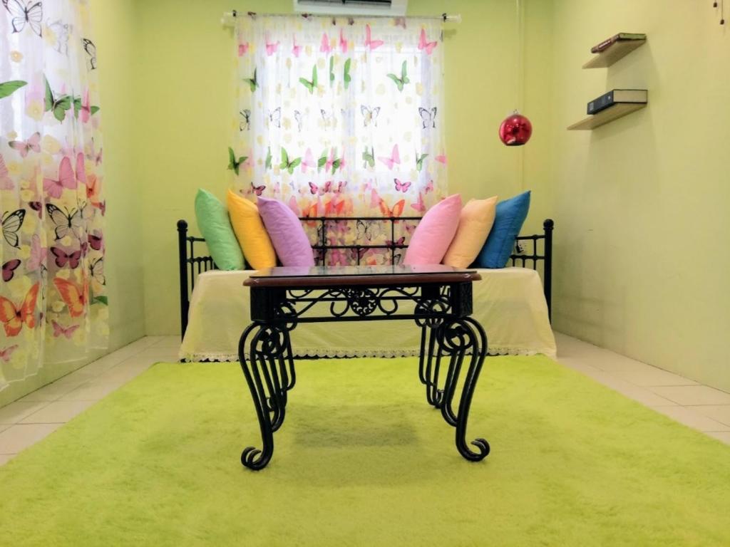 蕉赖2 BR Medina Dollar Landed Homestay Cheras MRT Link的客房配有带色彩缤纷枕头和桌子的床。