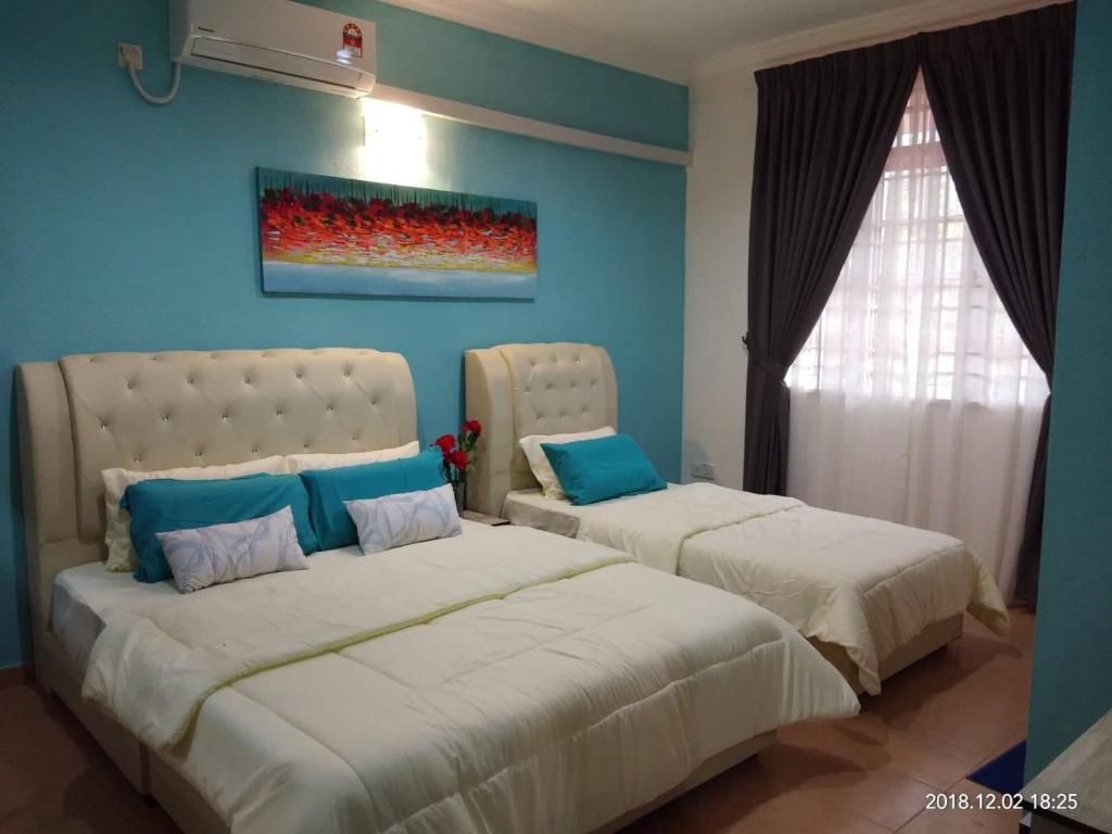 KeterehaAdy Homestay的卧室设有两张床铺和蓝色的墙壁