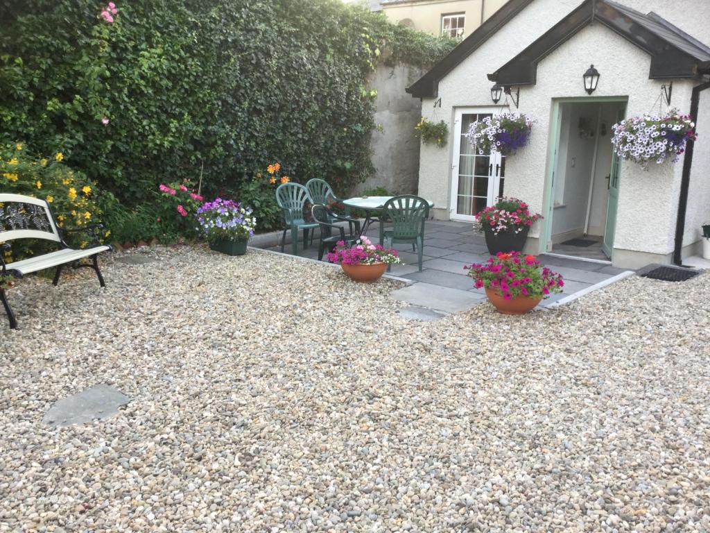 RameltonCrammond House的庭院配有桌椅和鲜花