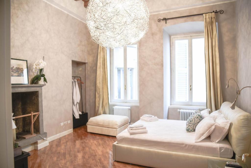 贝加莫Ilsanleonardo的卧室配有一张白色大床和吊灯。