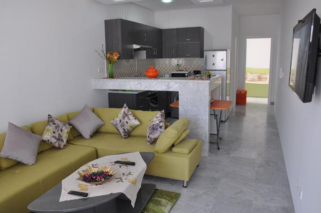 马赫迪耶Apartment zone touristique 80 m beach free wifi的一间带黄色沙发的客厅和一间厨房