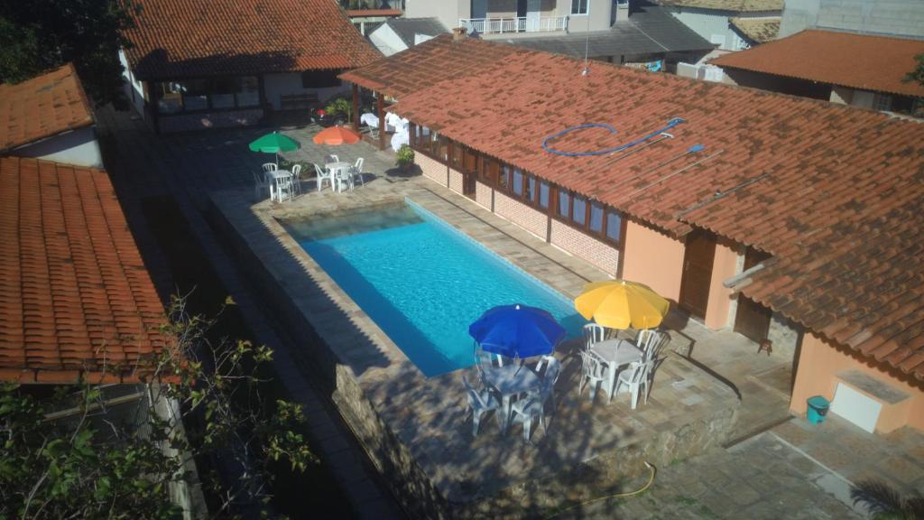 萨夸雷马Pousada Solar Tropical的游泳池顶部景,带遮阳伞