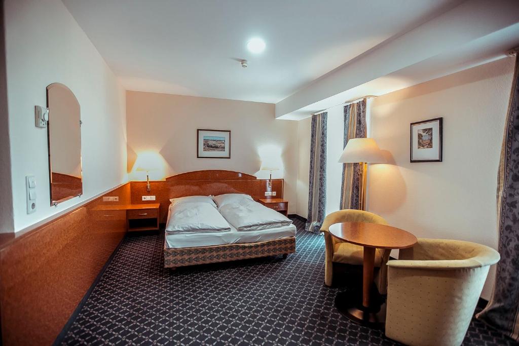 塔什干索德里克宫酒店的酒店客房,配有床、桌子和椅子