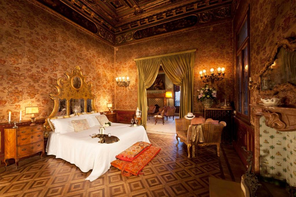 威尼斯大运河皮萨尼宫酒店的卧室配有一张床,上面放着一只猫