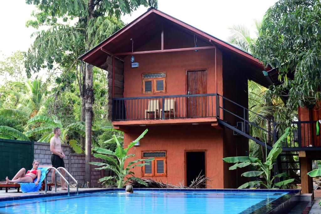丹不拉Sun and Green Eco Lodge - Dambulla的一座带游泳池的度假村,位于一座房子前