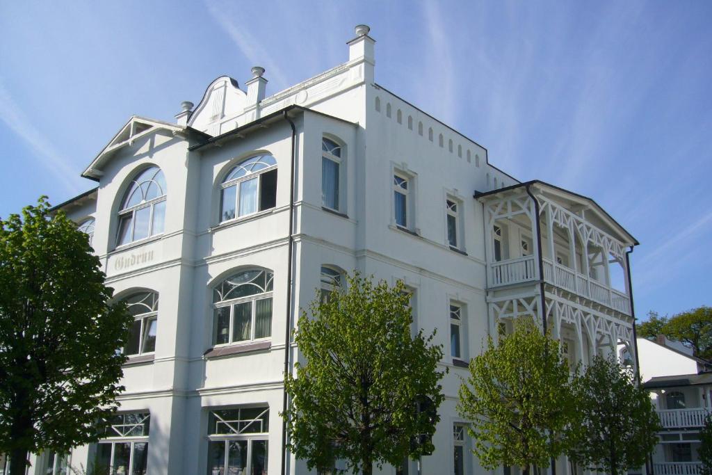宾茨Meerblick-Appartement Villa Gudrun的前面有树木的白色建筑