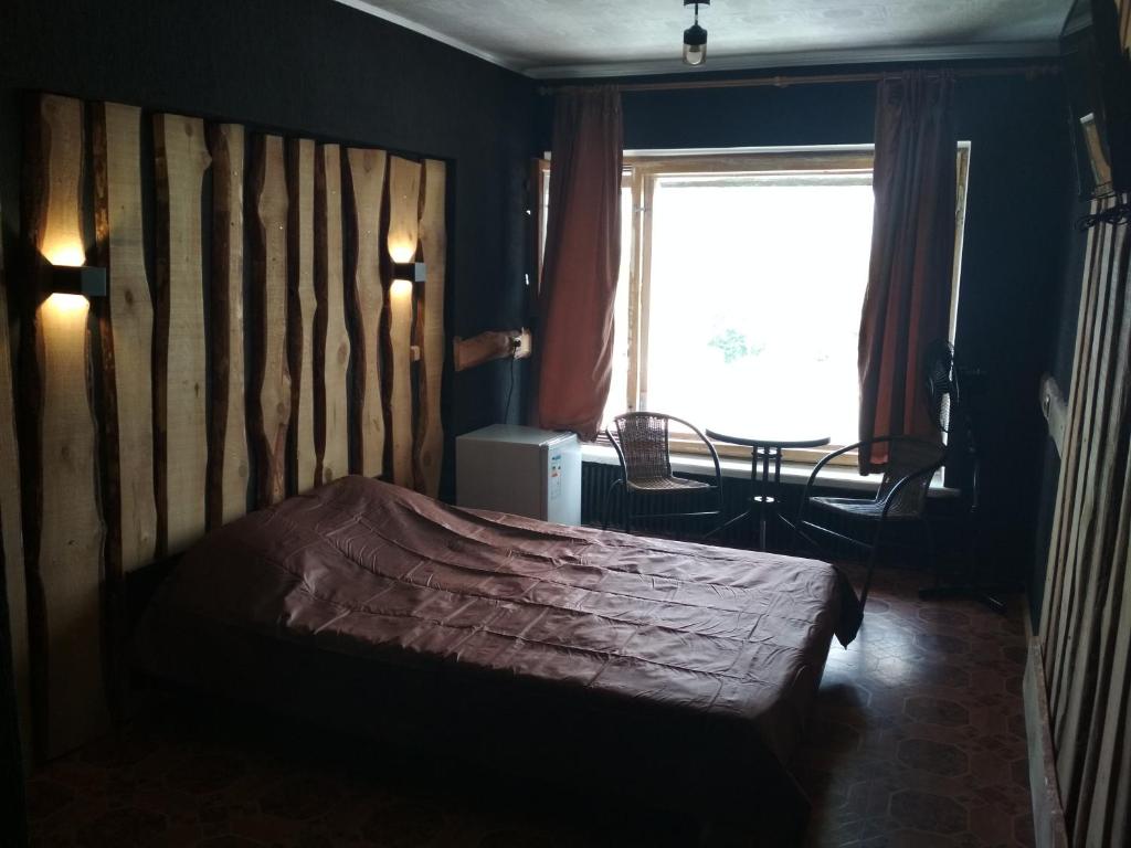 波尔塔瓦Готель на Автовокзалі的一间卧室配有一张带木制床头板的床和窗户。