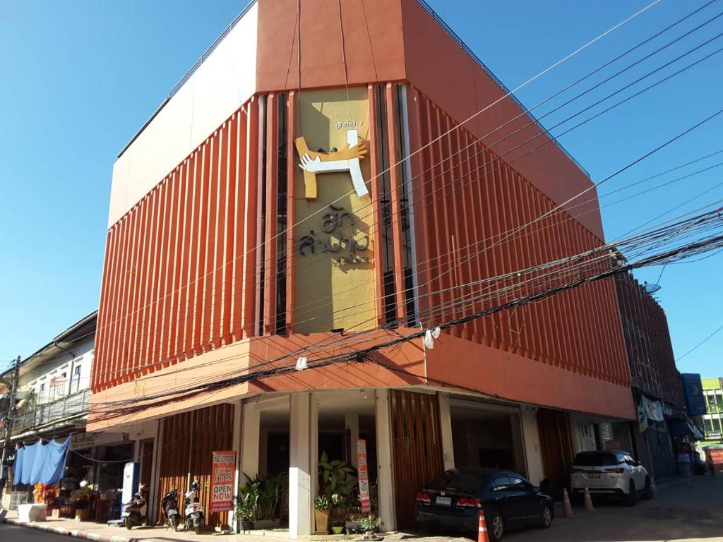 南邦Huglampang Boutique Hotel的一面有窗户的红色建筑