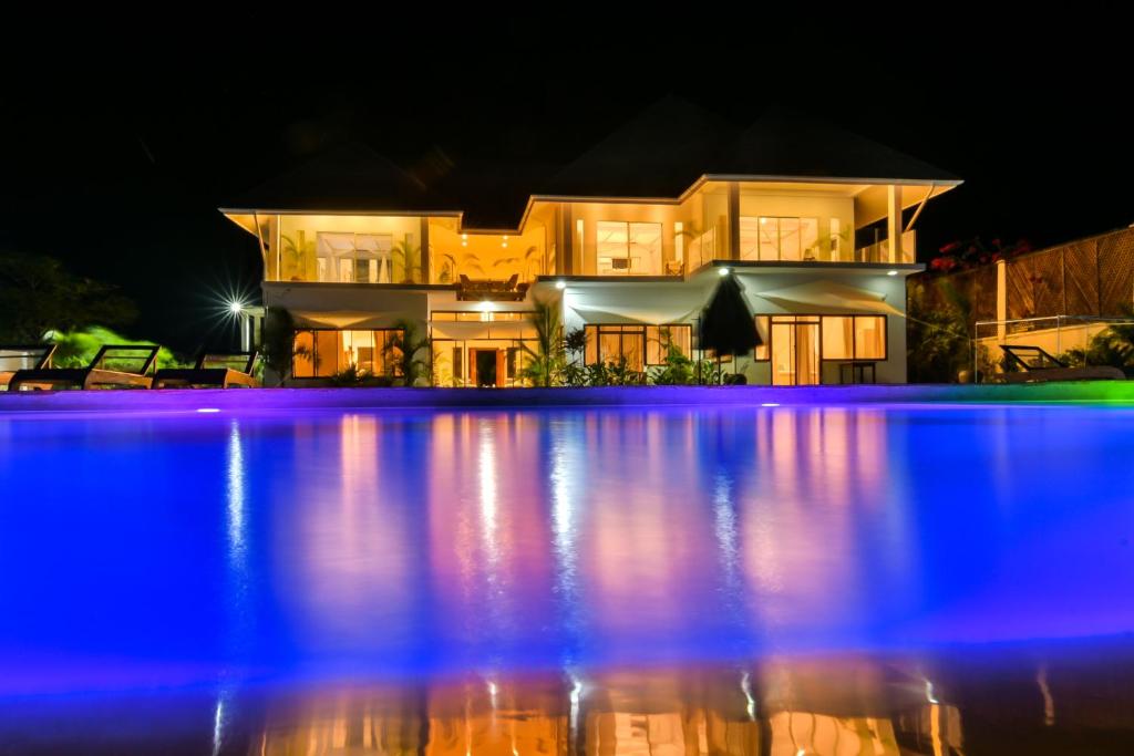 ChanjaniThe Palm Residence by Amazing Zanzibar的一座晚上设有游泳池的房子