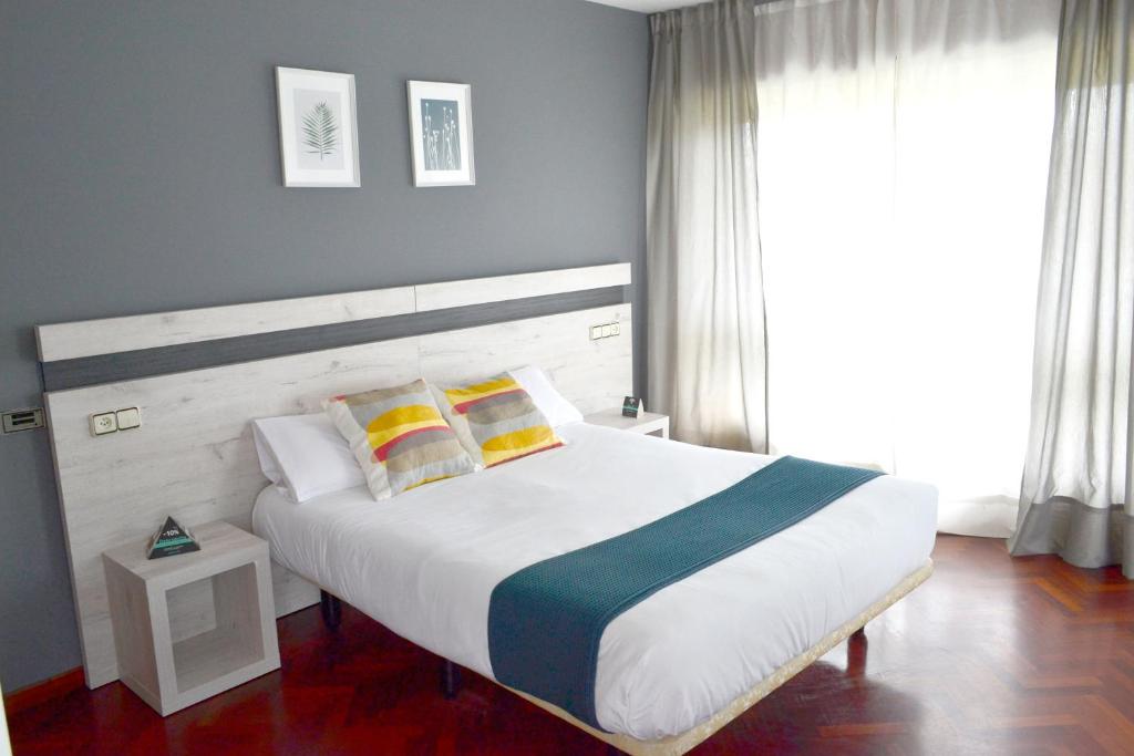 拉科鲁尼亚Alda Puerta Coruña的卧室设有一张白色大床和一扇窗户。