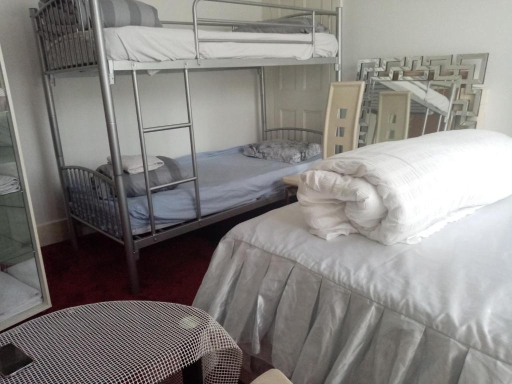 伦敦Alys apartment的配有2张双层床的客房配有桌子和椅子