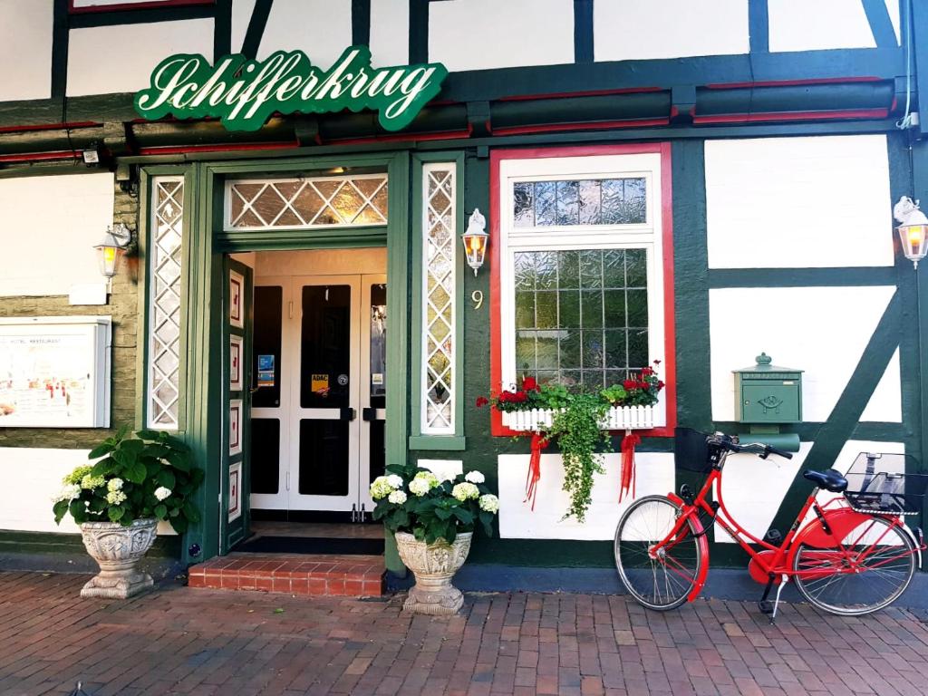 策勒Schifferkrug Hotel & Weinstube的停在大楼前的一辆红色自行车