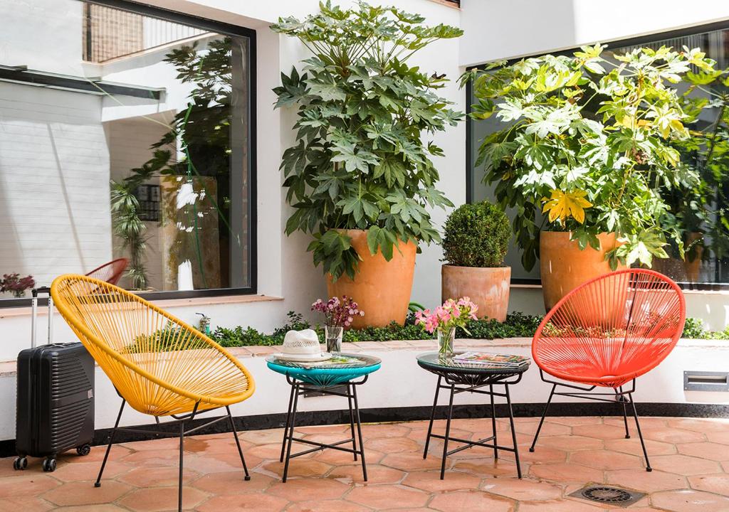 塞维利亚Feria Pool & Luxury的庭院设有三把椅子和一张带鲜花的桌子