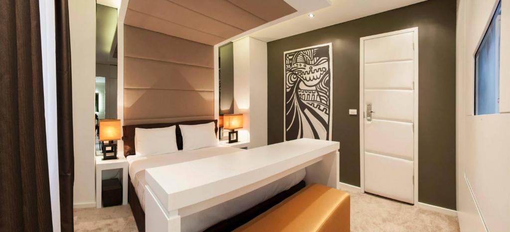 贝尔格莱德伊甸花园套房旅馆的卧室配有白色的床和墙上的绘画作品