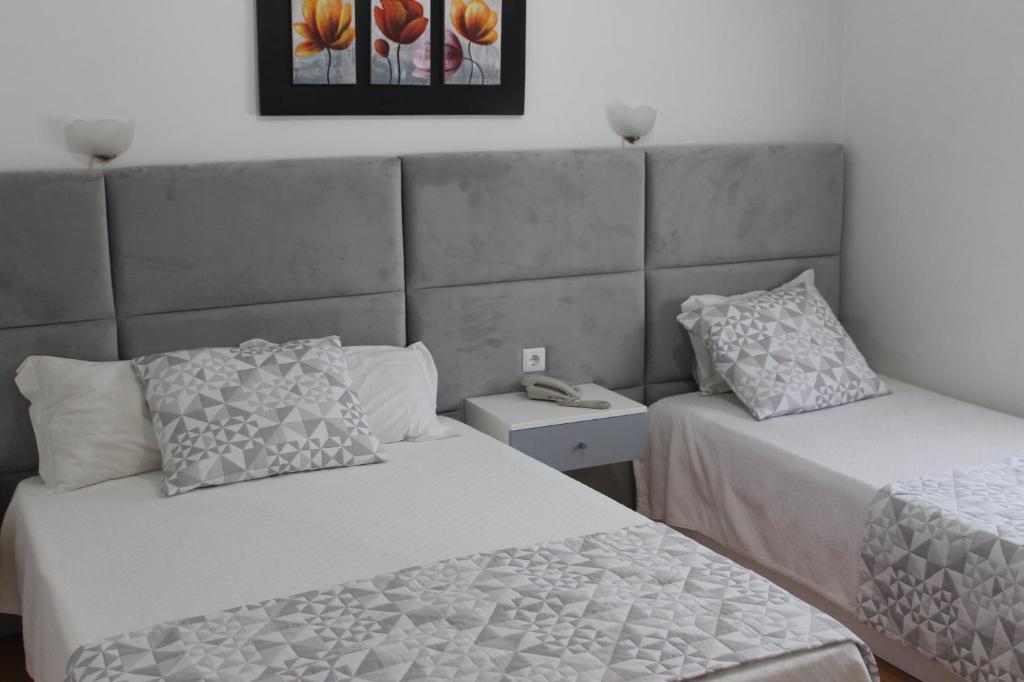 米兰达·杜·杜罗Alojamento Local Santa Cruz的一间卧室配有两张床和床头板