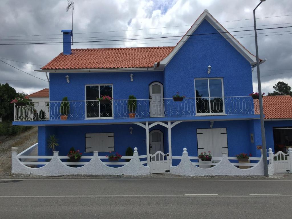 CabaçosCasa De Newsham的前面有白色围栏的蓝色房子