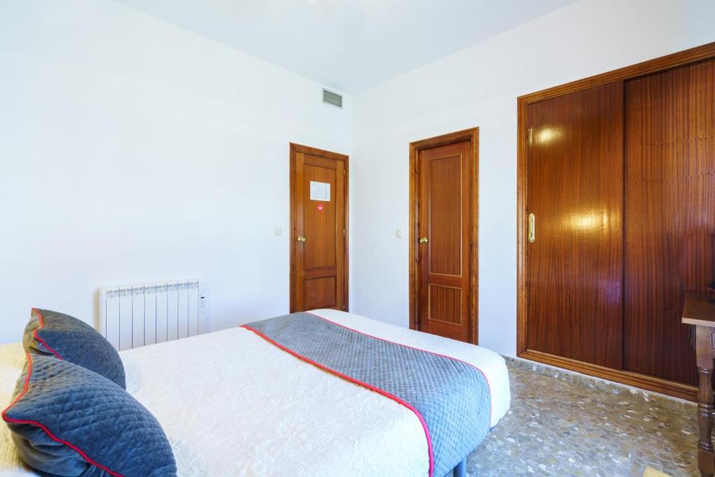 莫内斯特里奥HOTEL RESTAURANTE MOYA的一间卧室配有一张床和一个木制橱柜