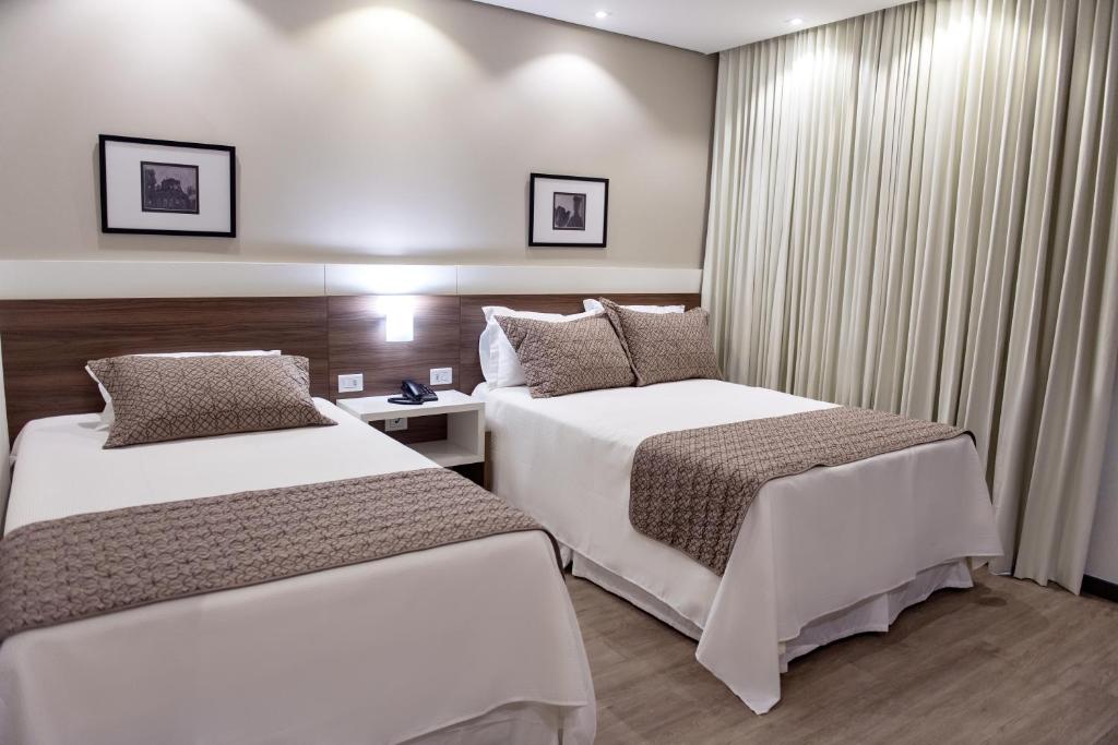圣安热卢Villas Hotel的酒店客房设有两张床和窗户。
